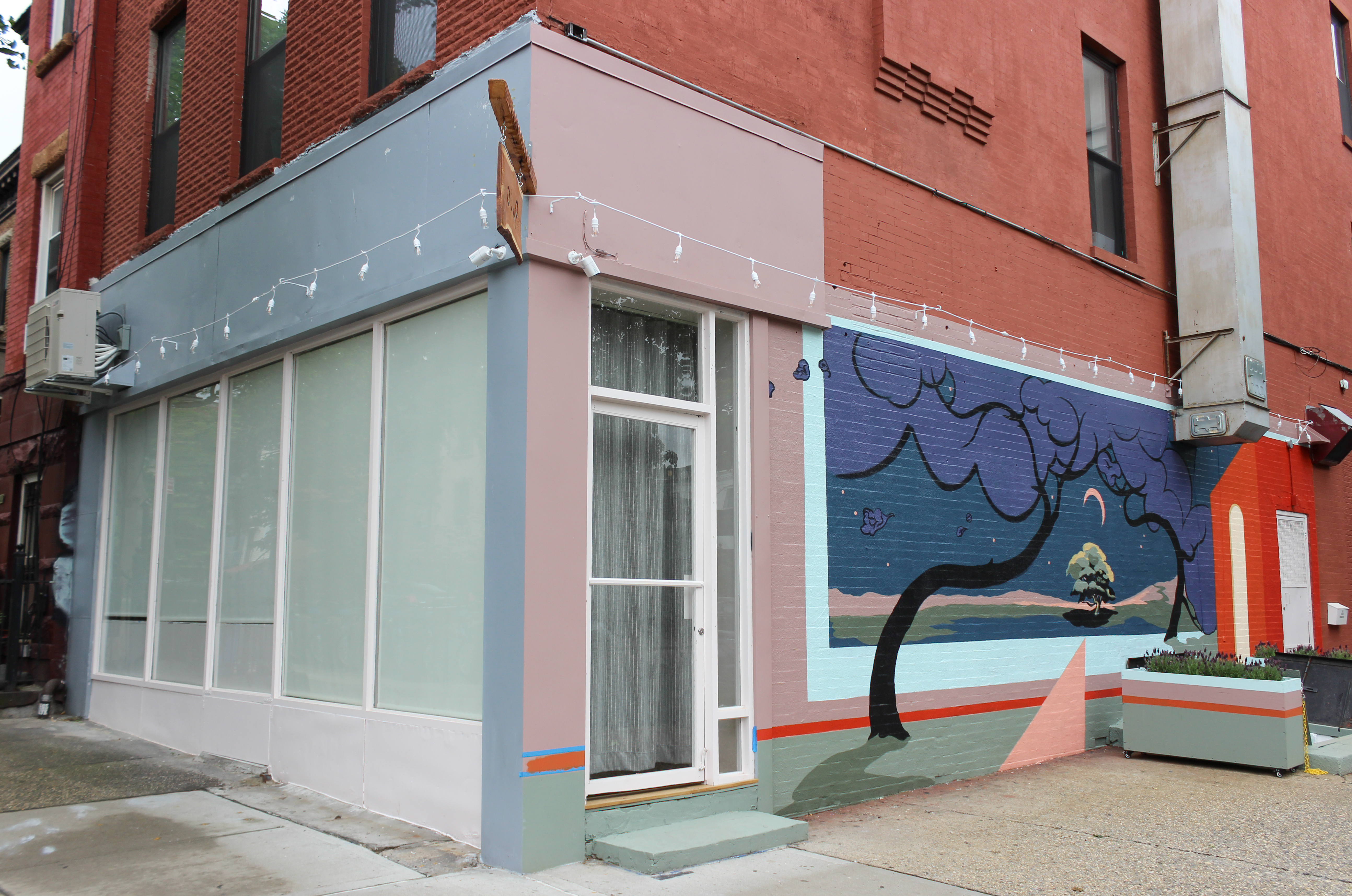 storefront papered over and a mural painted on the side